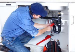  Apache Junction plumber repairs a sink drain with a pipe wrench